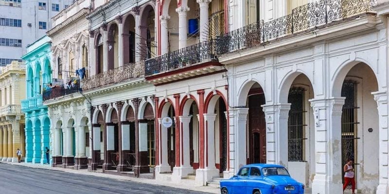 Coche azul en frente de casas coloniales a La Habana, Cuba. Viaje a Cuba